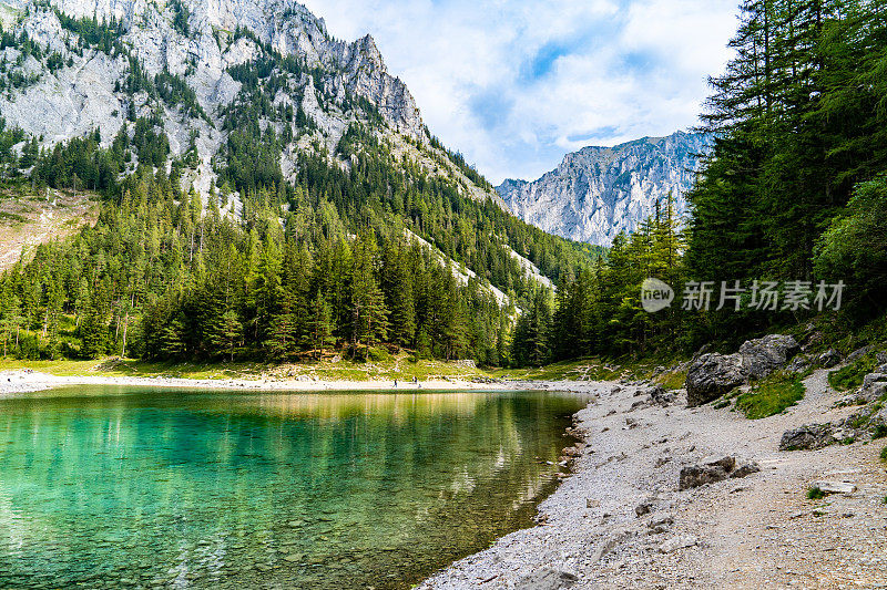 Grüner See (Green Lake) -奥地利的山湖，被松树林和巨大的山脉包围。蓝色多云的天空在背景上。